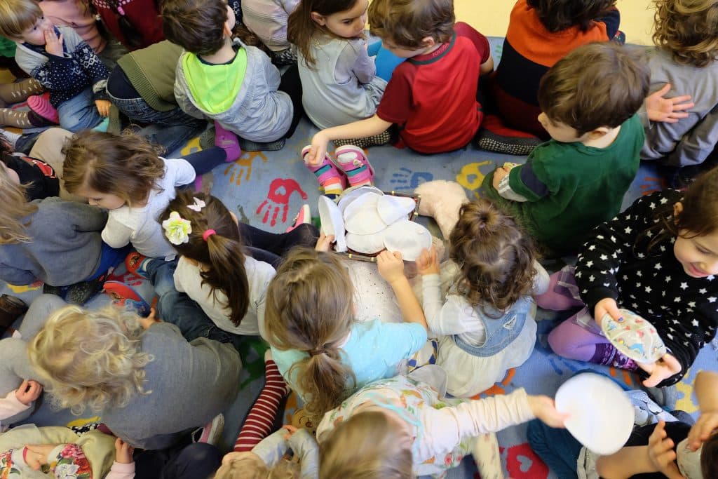 Kinder der Masorti Kita versammeln sich zu einer Vorführung auf einer selbst gedruckten Decke. © Masorti Kitas